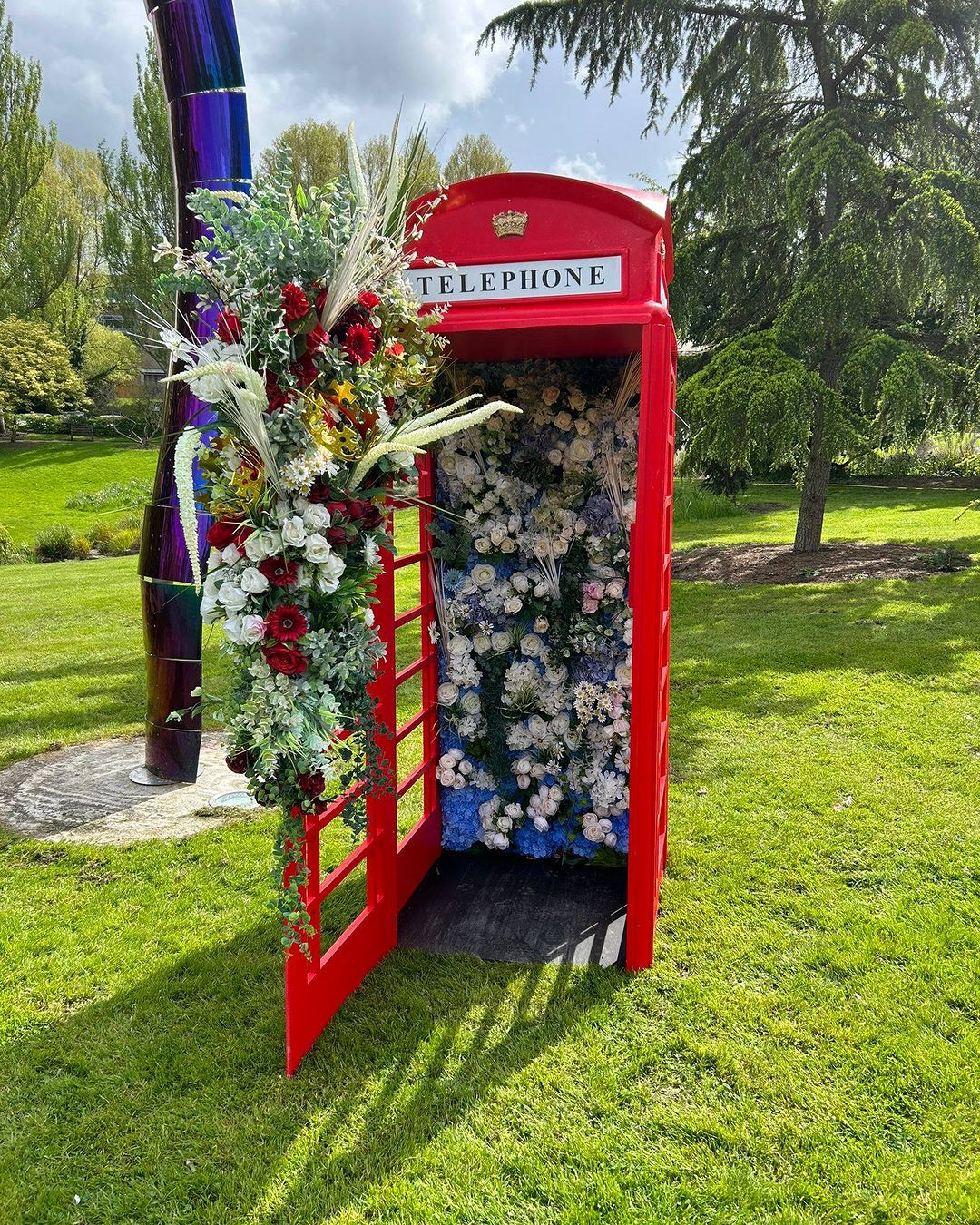 red telephone box filled with flowers