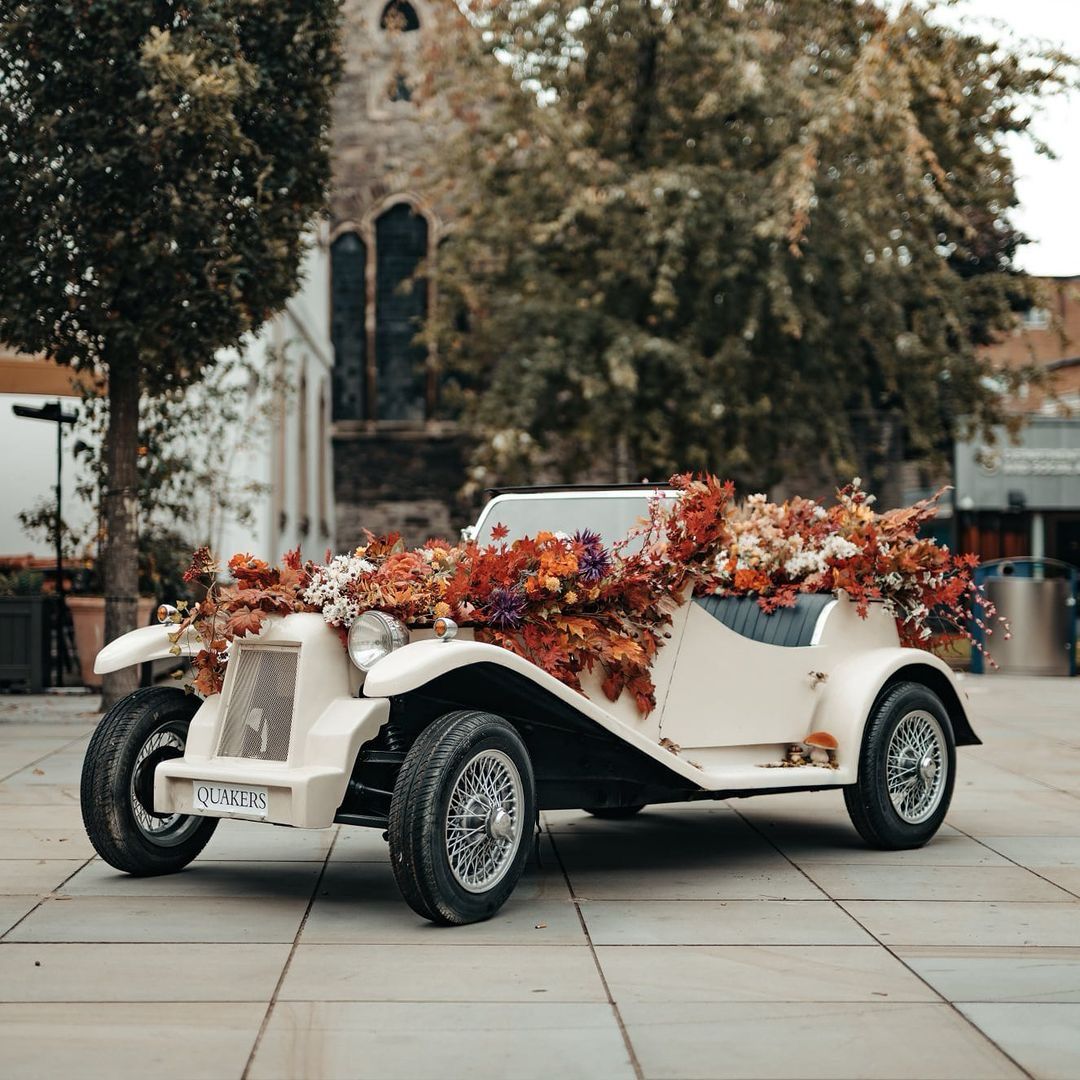 Autumn flower display overflowing out of a classic car